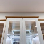 This His and Hers small walk in closet has a glass enclosed cabinet adding to the luxury feel of your home.