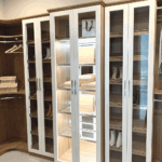 View of the glass enclosed cabinet and shoe shelves.