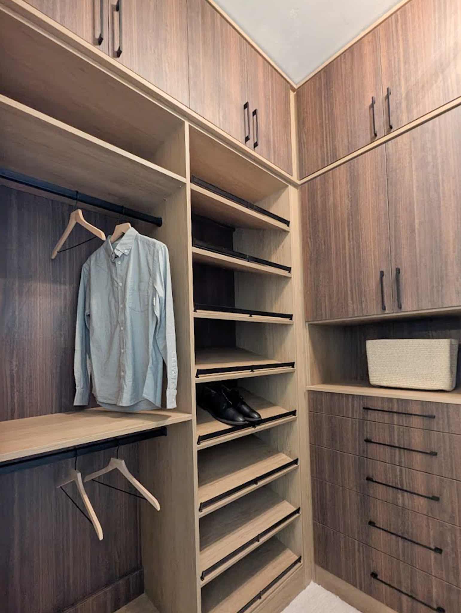 Brown wood grain custom walk-in closet with cabinets, dresser, and shoe shelves