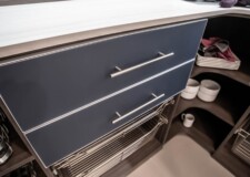 A custom built pantry drawer with large steel handles and steel baskets underneath custom built pantry drawer with large steel handles