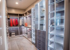 The illuminated shoe racks, display cabinets and custom drawers with crocodile pattern drawer fronts make this walk in closet extravagant Sophisticated lighted shoeracks and cabinets with elegant crocodile pattern drawer fronts