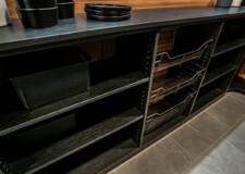This custom kitchen pantry design in a Sandalwood model home project looks absolutely stunning with its dark shaded shelves and steel baskets Walk In Kitchen Pantry Ideas Las Vegas, NV