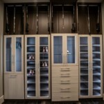 The sophisticated Her side of luxurious closet in a master bedroom with his and hers closets in Las Vegas has white shaded wooden cabinets for a clean look.