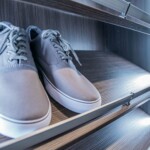 The shoe rack’s interior LED lighting system is a vital part of a luxury closet in a master bedroom with his and hers closet.
