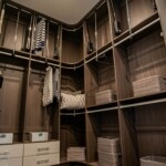 In this Las Vegas master bedroom with his and hers closets, the Her side corner of the closet has pull-down rails and adjustable shelves for smart storage.