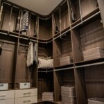 In this Las Vegas master bedroom with his and hers closets, the Her side corner of the closet has pull-down rails and adjustable shelves for smart storage.