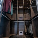 The his side of his and hers closet designs by Closets Las Vegas shows off the grand shelving system with adjustable rods and shelves.