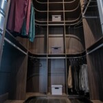 The his side of his and hers closet designs by Closets Las Vegas shows off the grand shelving system with adjustable rods and shelves.