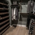 View of the wooden shoe shelves and cabinet of the His and Hers walk in closet.