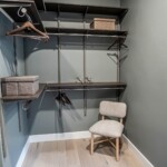 View of his side of the closet with double hang closet rods and shelves.