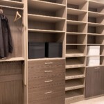 This functional closet design for men features a dresser drawer, shoe organizer with slanted shelves, and a pull out hamper.