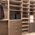 This functional closet design for men features a dresser drawer, shoe organizer with slanted shelves, and a pull out hamper.