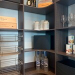 This custom pantry design features a deep rounded corner design, and wire baskets to take what you need and go.