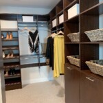 This His & Hers small walk in closet features a hidden pull out hamper, double hang and long hang shelves, and slanted shoe shelves. His And Her Walk In Closet Las Vegas, NV