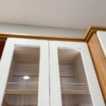 Closer look of the slanted shoe shelves in a glass enclosed cabinet.