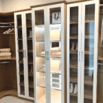 View of the glass enclosed cabinet and shoe shelves.