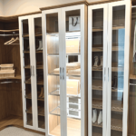 View of the glass enclosed cabinet and shoe shelves.