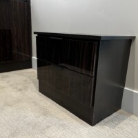 This walk in closet also features a small disconnected bench with drawers!