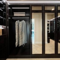 Two types of doors were used in this walk in closet. One of them is a mirrored door in lacquer-finished walnut.