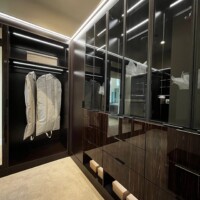 This custom walk in closet in Las Vegas features a black aluminum frame closet door.